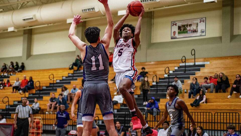 iAtascocita's Adam Boyd (5) puts up a shot over Klein Cain's Nick Delgado (11) in the first half of a boys high school basketball game Tuesday, Dec. 19, 2023 at Atascocita High School.