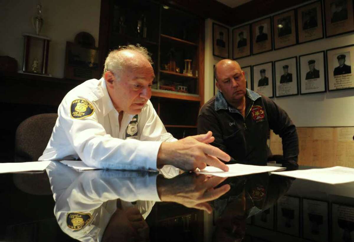 Joe Kaliko, president of the Cos Cob Fire Police Patrol, Inc., left, and Robert Grierson, deputy chief of the Volunteer Hose and Chemical Company, go over the outline of their concerns about housing the central fire station in their Cos Cob fire station, on Wednesday, Ocy. 27, 2010.
