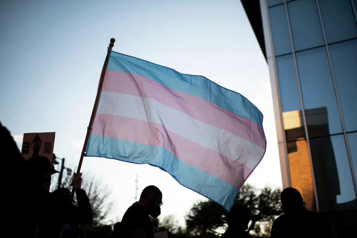 A protester waves a transgender pride flag during a protest at the University of North Texas in Denton on March 23, 2022. 