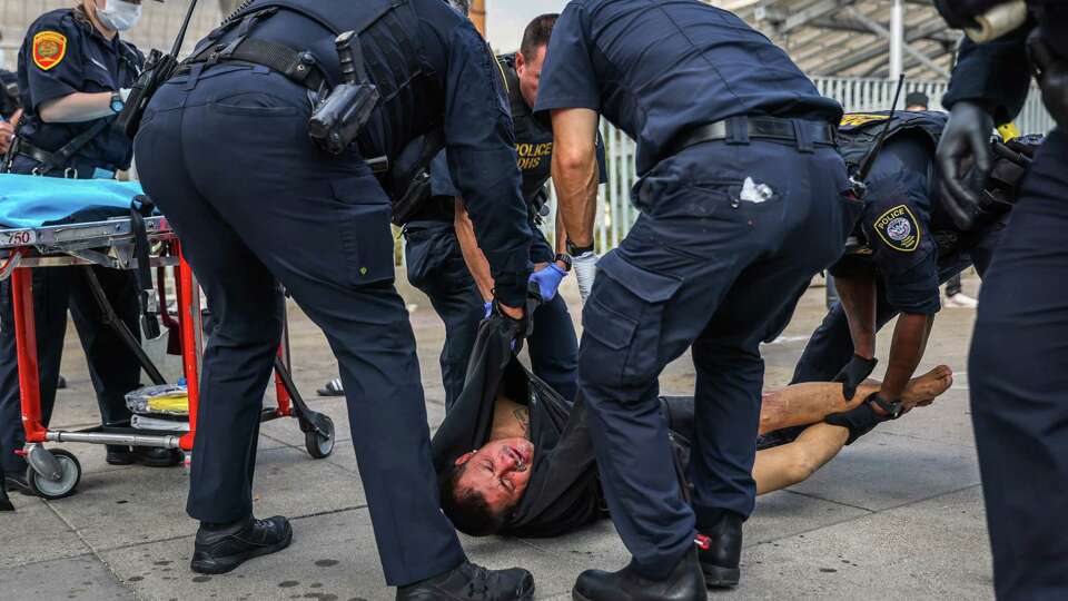 A man who survived a drug overdose is carried away by medical personnel on Mission Street near 7th Street near the Federal Building in San Francisco on Tuesday, Sept. 19, 2023. He was revived by an unhoused drug user because Federal Marshall’s said they were untrained to intervene.