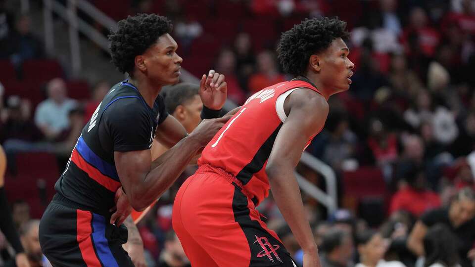 Houston Rockets forward Amen Thompson (1) tags up with his brother Detroit Pistons forward Ausar Thompson (9) in the first half of game action at the Toyota Center on Monday, Jan. 1, 2024 in Houston.