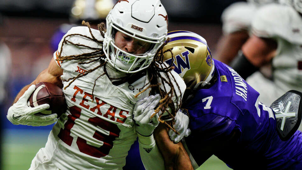 Texas wide receiver Jordan Whittington (13) runs against Washington cornerback Dominique Hampton (7) during the first half of the Sugar Bowl CFP NCAA semifinal college football game, Monday, Jan. 1, 2024, in New Orleans. (AP Photo/Jacob Kupferman)