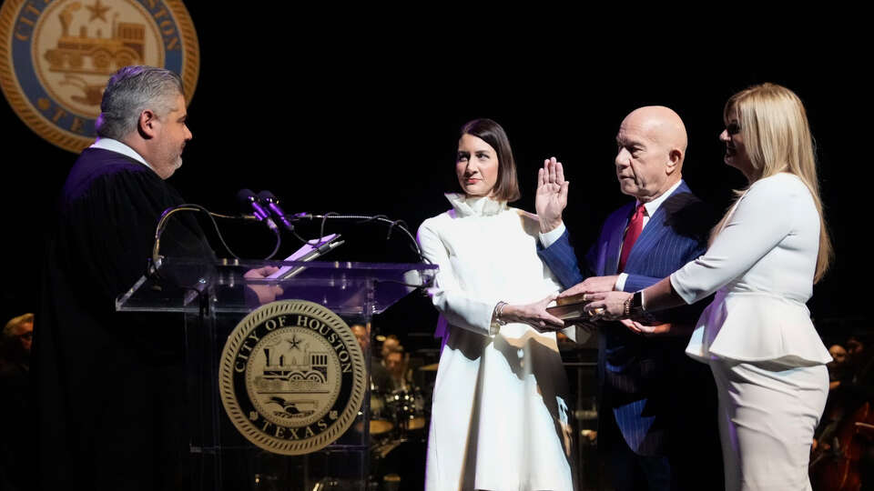 Judge Victor Trevino III conducts the swearing-in ceremony during inauguration event at the Wortham Center with Mayor John Whitmire and his daughters, Whitney Whitmire Jenkins, left, and Sarah Whitmire, right, Tuesday, Jan. 2, 2024 in Houston.