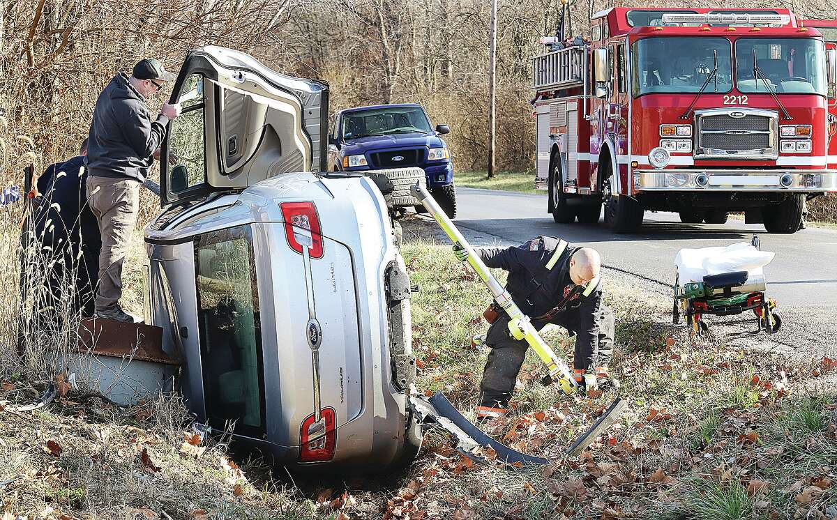 A Bethalto firefighter attaches a stabilization pole to the under side of a Ford Taurus which crashed Tuesday on Culp Lane in Bethalto. It took firefighters almost an hour to cut the driver from the car. 