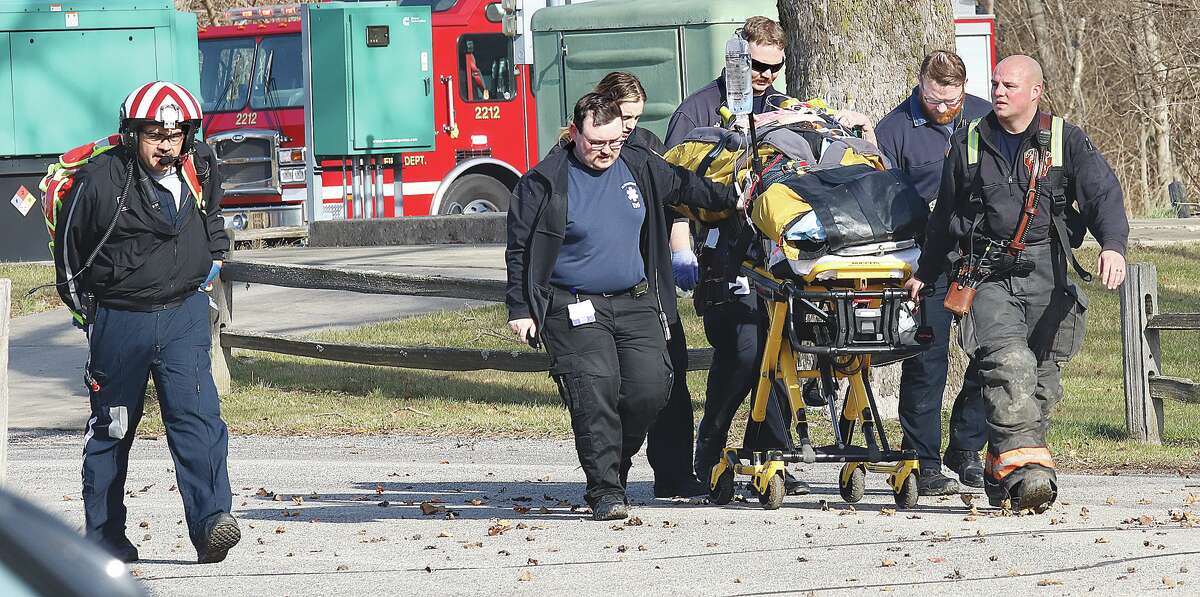 First responders, including the flight nurses of an Air Evac Lifeteam helicopter ambulance, wheel the driver to the helicopter for transport to a St. Louis trauma center.