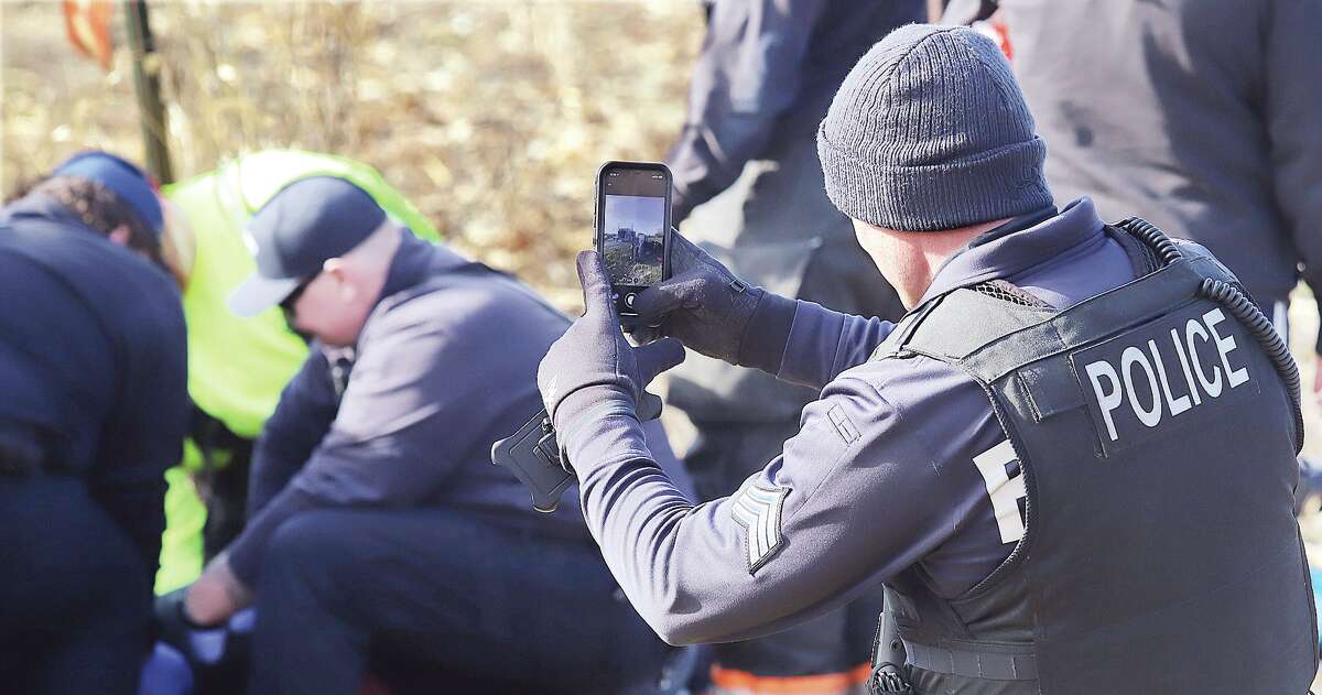 A Bethalto police sergeant photographs the scene during his investigation Tuesday on Culp Lane.