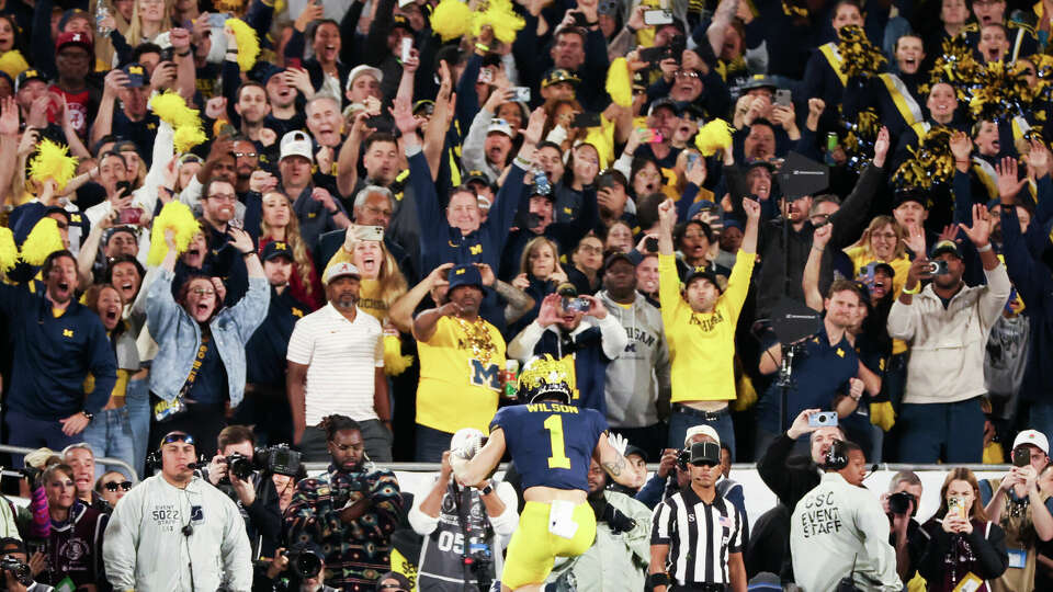 Michigan Wolverines fans react as receiver Roman Wilson (1) leaps into the end zone to tie the game against Alabama in the fourth quarter of the College Football Playoff semifinals at the Rose Bowl on Monday, Jan. 1, 2024. A lot of those fans will be making the trip to Houston for Monday's national championship game.