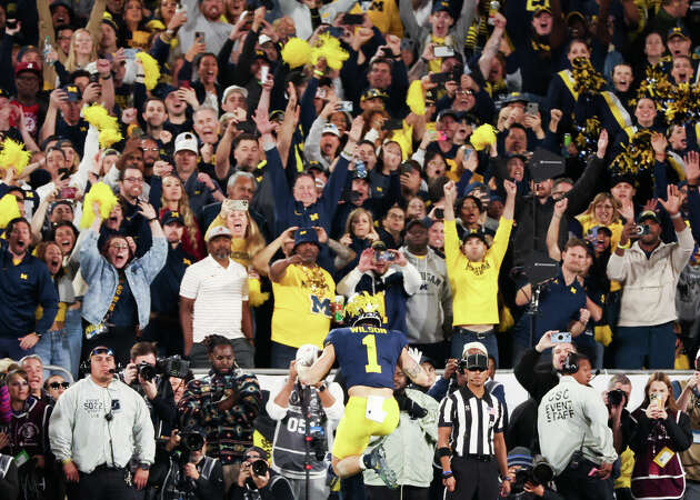 Michigan Wolverines fans react as receiver Roman Wilson (1) leaps into the end zone to tie the game against Alabama in the fourth quarter of the College Football Playoff semifinals at the Rose Bowl on Monday, Jan. 1, 2024. A lot of those fans will be making the trip to Houston for Monday's national championship game.