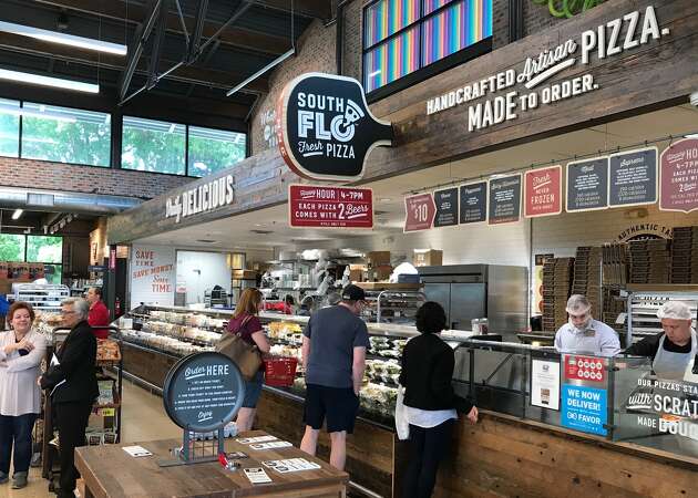 Shoppers near a South Flo Pizza in H-E-B.