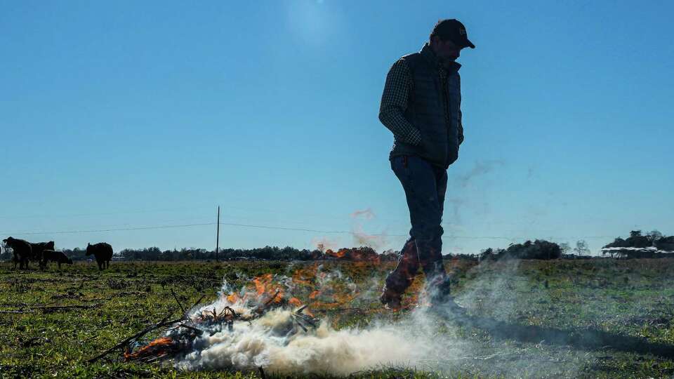 Richie DeVillier, 60, watches over a controlled debris fire on his ranch on Thursday, Jan. 4, 2024, in Winnie. DeVillier and some of his neighbors are suing the state of Texas for expanding the I-10 freeway near his home in a way he says has caused his and neighboring homes to flood severely.