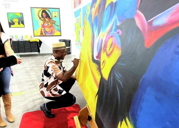 Elijah Alhadji Gibson, founder/artistic director of Social Movement Contemporary Dance Theater, autographing the picture wall.