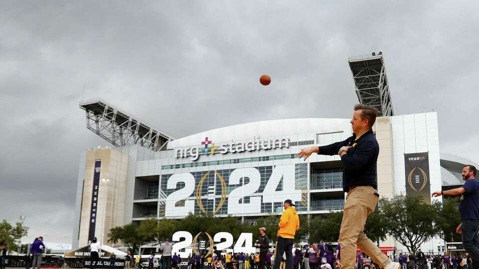 Fans play on a turf field in the parking out outside NRG Stadium before the 2024 National Championship at NRG Stadium on Monday, Jan. 8, 2024 in Houston.