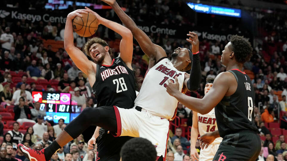 Houston Rockets center Alperen Sengun (28) and Miami Heat center Bam Adebayo (13) go after a rebound during the second half of an NBA basketball game, Monday, Jan. 8, 2024, in Miami. (AP Photo/Marta Lavandier)