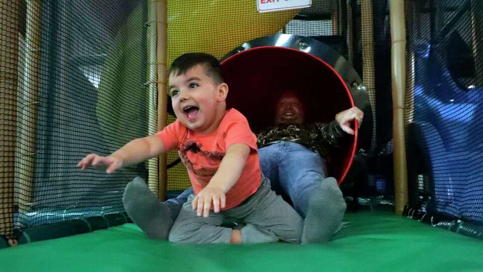 Four year old Carter Sommers, left, a Duchenne Muscular Dystrophy patient, exits a tube slide with his father, Curtis Sommers, right, at the indoor playground at The Woodlands Church Monday, Jan. 8, 2024 in The Woodlands, TX. Carter has received gene therapy treatments that have allowed him to progress from trouble with walking to full mobility of climbing and jumping.