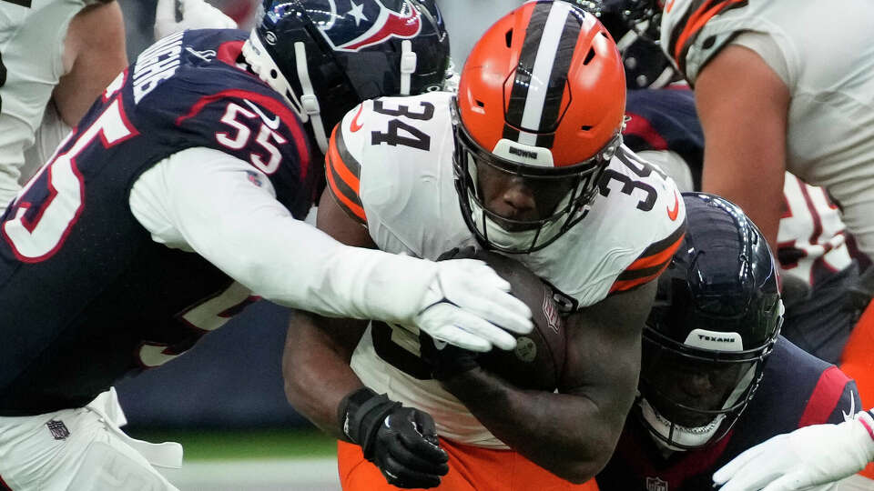 Houston Texans defensive end Jerry Hughes (55) and linebacker Myjai Sanders (41) tackle Cleveland Browns running back Jerome Ford (34) during the second quarter of a NFL game on Sunday, Dec. 24, 2023 at NRG Stadium in Houston.