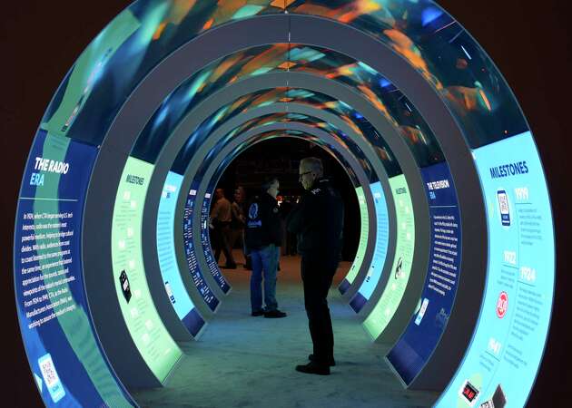 People look at a CES exhibit during the CES tech show Tuesday, Jan. 9, 2024, in Las Vegas.