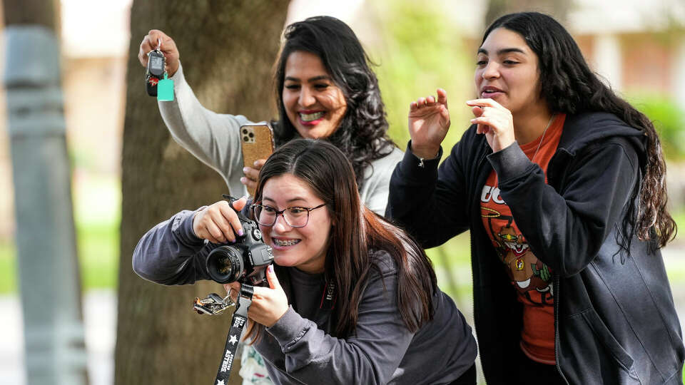 Alexis Serrato photographs family Christmas photos with the help of her assistant, Tabitha Castillo, 17, on an esplanade on Sunday, Dec. 3, 2023, in Pasadena.