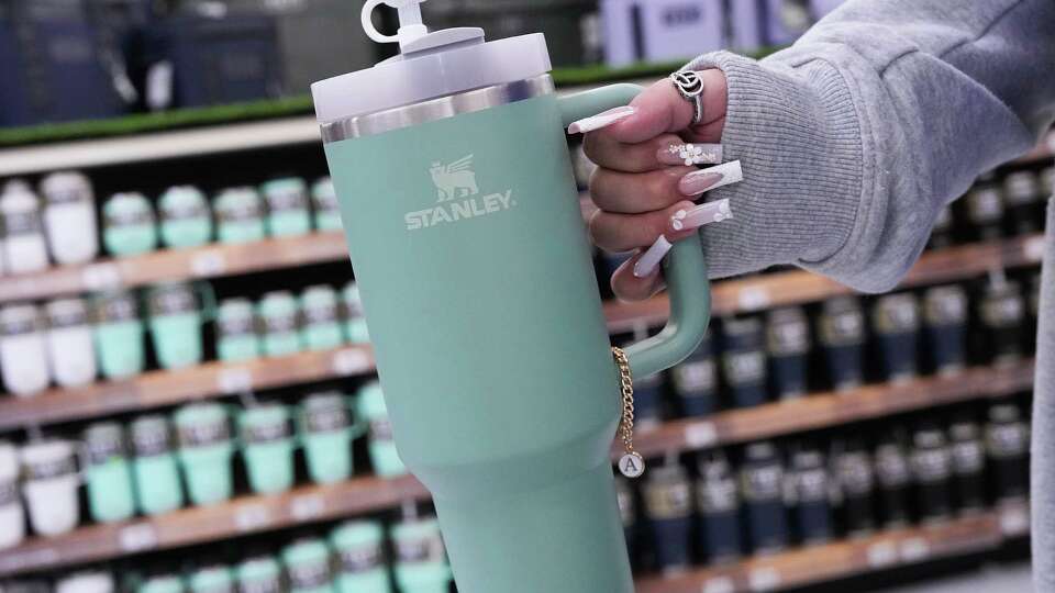 An Academy Sports + Outdoors employee shows off her decorated Stanley Quencher tumbler at the store on Wednesday, Jan. 10, 2024 in Houston. The store had sold out of Stanley's 40 oz Quencher style as it has recently become a hot trending item.