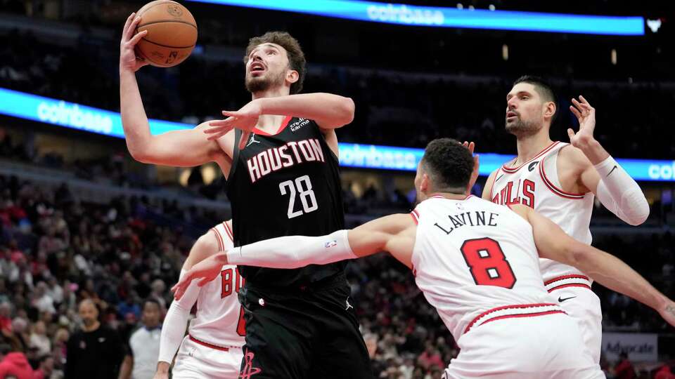 Houston Rockets' Alperen Sengun (28) drives to the basket past Chicago Bulls' Zach LaVine (8) and Nikola Vucevic during overtime in an NBA basketball game Wednesday, Jan. 10, 2024, in Chicago. The Bulls won 124-119. (AP Photo/Charles Rex Arbogast)