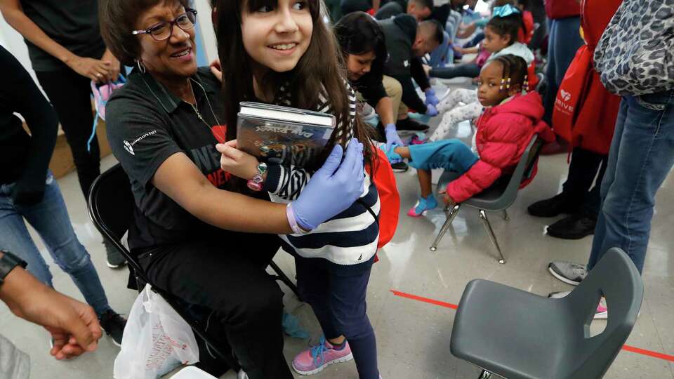 Valeria Maciel, 9, gets a hug from volunteer Liz Galloway after getting her new shoes and socks at Martin Luther King, Jr. Early Childhood Center, in Houston, Monday, Jan. 20, 2020. Houston Independent School District Board of Education Trustee Wanda Adams has partnered with national charity Samaritan's Feet to supply 500 pairs of shoes, enough for every student at Martin Luther King, Jr. Early Childhood Center, part of her District IX MLK Day of Service.