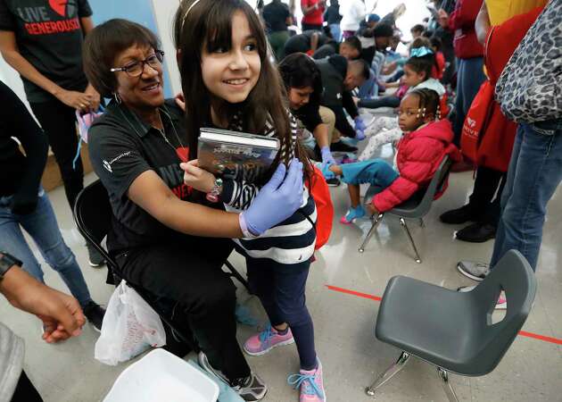 Valeria Maciel, 9, gets a hug from volunteer Liz Galloway after getting her new shoes and socks at Martin Luther King, Jr. Early Childhood Center, in Houston, Monday, Jan. 20, 2020. Houston Independent School District Board of Education Trustee Wanda Adams has partnered with national charity Samaritan's Feet to supply 500 pairs of shoes, enough for every student at Martin Luther King, Jr. Early Childhood Center, part of her District IX MLK Day of Service.