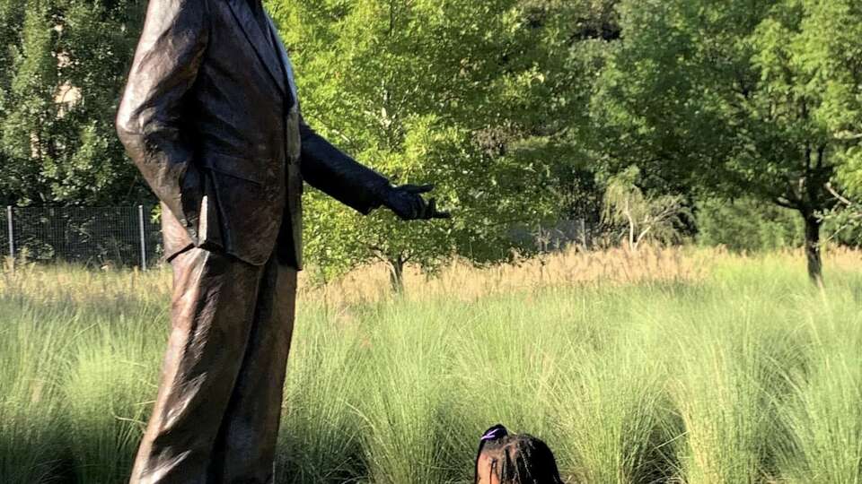 A young girl reads the inscription at the MLK statue at Hermann Park. 