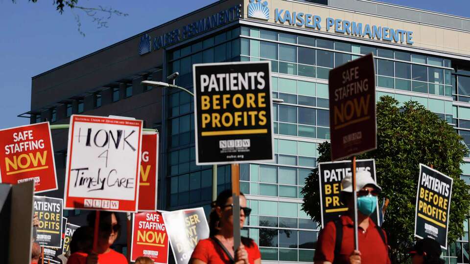 Mental healthcare workers with the National Union of Healthcare Workers picket outside of the Kaiser Permanente facility on Broadway in Oakland, Calif. Tuesday, Aug. 16, 2022 over workload issues that are at issue in their contract negotiations with Kaiser.