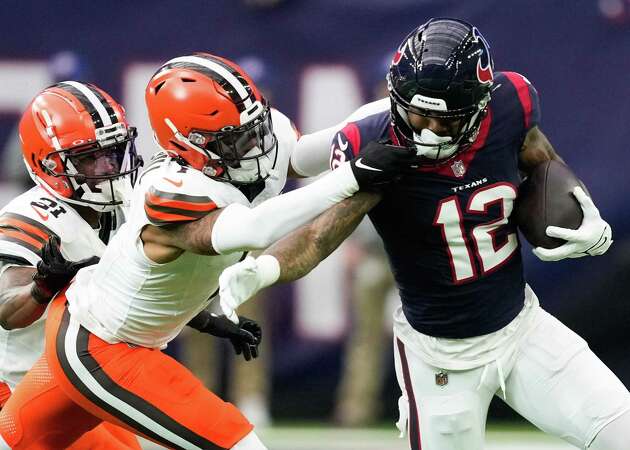 Houston Texans wide receiver Nico Collins (12) is brought down by Cleveland Browns safety Juan Thornhill (1) in front of cornerback Denzel Ward (21) during the first half of an AFC Wild Card football game at NRG Stadium on Saturday, Jan. 13, 2024, in Houston.