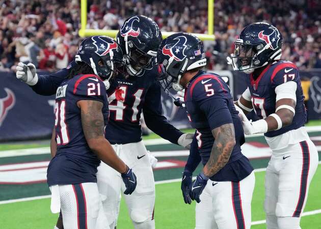 Houston Texans players celebrate after cornerback Steven Nelson, left, returned an interception of Cleveland Browns quarterback Joe Flacco for an 82-yard touchdown during the second half of an AFC Wild Card football game at NRG Stadium on Saturday, Jan. 13, 2024, in Houston.