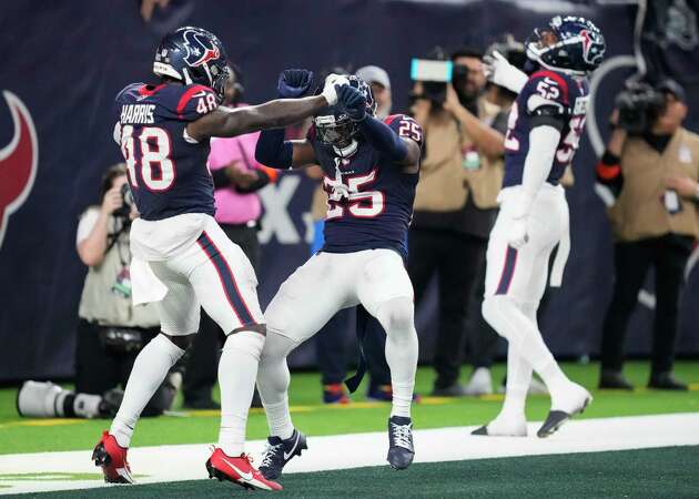 Houston Texans safety Desmond King II, center, celebrates with linebacker Christian Harris, left, after Harris intercepted Cleveland Browns quarterback Joe Flacco and returned it for a 36-yard touchdown during the second half of an AFC Wild Card football game at NRG Stadium on Saturday, Jan. 13, 2024, in Houston.