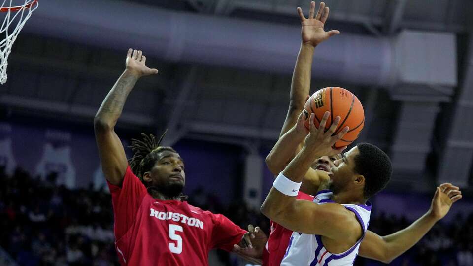 TCU guard Jameer Nelson Jr., right, goes up for a shot agains Houston forward Ja'Vier Francis (5) and guard L.J. Cryer during the first half of an NCAA college basketball game, Saturday, Jan. 13, 2024, in Fort Worth, Texas. (AP Photo/Julio Cortez)