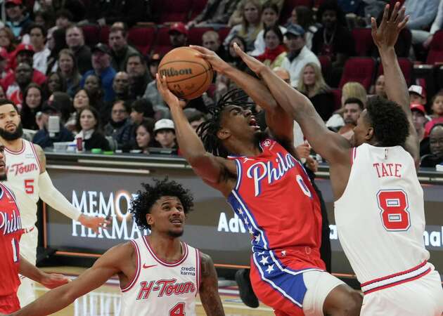 Philadelphia 76ers guard Tyrese Maxey (0) is fouled by Houston Rockets forward Jae'Sean Tate (8) during an NBA basketball game at Toyota Center, Friday, Dec. 29, 2023, in Houston.