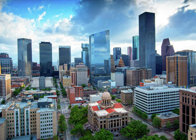 The skyscrapers of downtown Houston rise above the restored neo-classical 1910 Harris County Courthouse in downtown Houston, Texas.