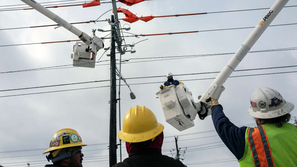 Workers repair a utility pole after a winter storm in Austin in 2021. State officials took steps to improve the grid after a disastrous failure in 2021, but officials continue to ask customers to conserve as demand nears capacity of the system.