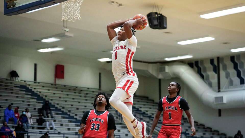 Bellaire's Shelton Henderson (1) goes up for a dunk past Lamar's Joseph O'Garro (33) and Kye Lee Smith (1) during an 18-6A high school basketball game on Wednesday, Jan. 17, 2024 in Houston.