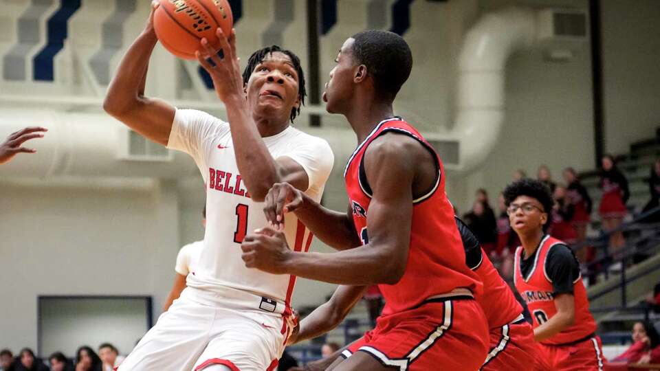 Bellaire's Shelton Henderson (1) drives to the basket against Lamar's Julien Magabo (21) during an 18-6A high school basketball game on Wednesday, Jan. 17, 2024 in Houston.