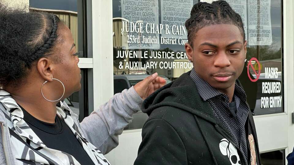 Darryl George, an 18-year-old high school junior, and his mother, Darresha George, stand outside a courthouse in Anahuac, Texas, on Wednesday, Jan. 24, 2024. A judge ordered Wednesday that a trial be held next month to determine whether George can continue being punished by his district for refusing to change a hairstyle he and his family say is protected by a new state law. (AP Photo/Juan A. Lozano)