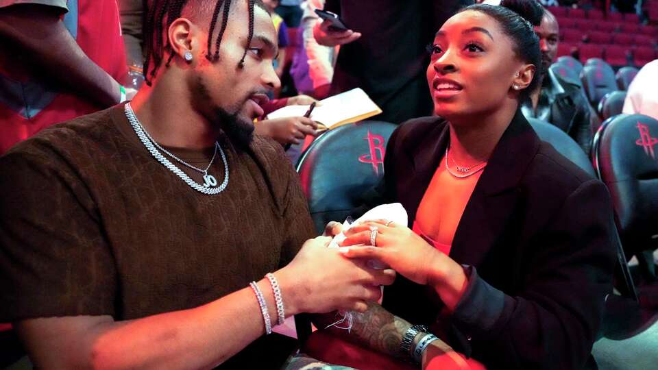 Green Bay Packers defensive back Jonathan Owens, left, and Olympic champion Simone Biles talk to fans after the Houston Rockets 135-119 win over the Los Angeles Lakers in an NBA basketball game on Monday, Jan. 29, 2024 in Houston.