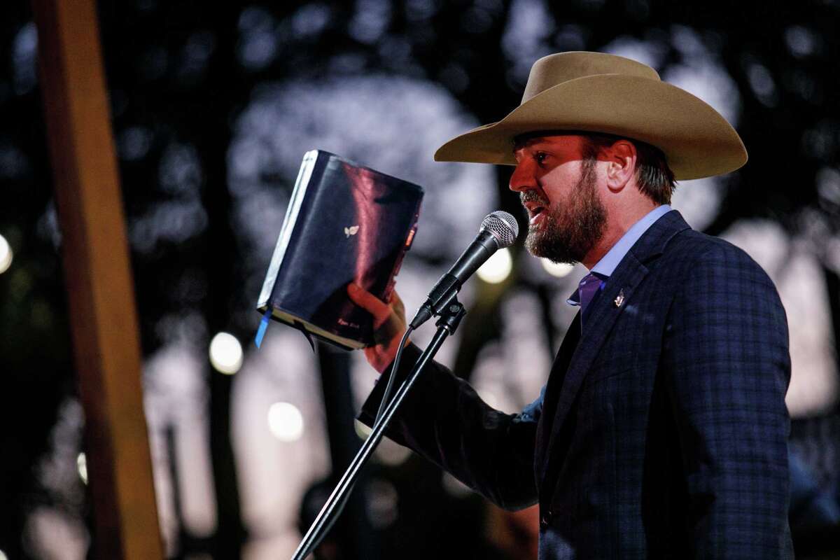 Ryan Zink of Lubbock holds up a bible as he talks to a large crowd of people attending the Take Our Border Back Convoy rally at One Shot Distillery and Brewery on Thursday, Feb. 1, 2024, in Dripping Springs, Texas. Zink was charged with one felony and two misdemeanors due to his involvement in the U.S. Capitol breach on Jan. 6, 2021.