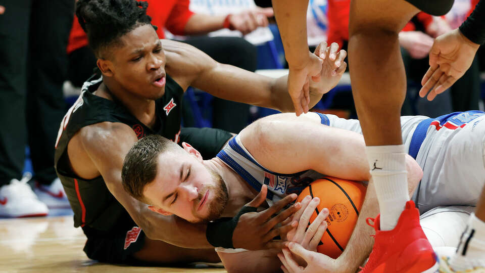 Kansas center Hunter Dickinson, bottom, gets control of the ball as Houston forward Joseph Tugler, top, defends during the second half of an NCAA college basketball game, Saturday, Feb. 3, 2024, in Lawrence, Kan. (AP Photo/Colin E. Braley)