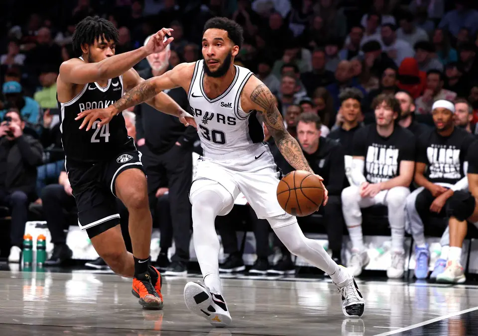 San Antonio Spurs forward Julian Champagnie (30) drives to the basket against Brooklyn Nets guard Cam Thomas (24) during the second half of an NBA basketball game, Saturday, Feb. 10, 2024, in New York. (AP Photo/Noah K. Murray)