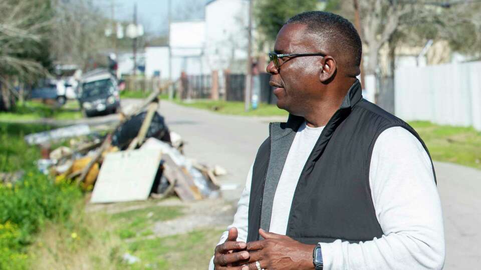 A pile of illegally dumped items is visible in the background as Melvin Hopkins, District K Constituent Services Director - Field Operations, walks back to his truck after evaluating a site with a long history of illegal dumping near S. Post Oak Boulevard Tuesday, Feb. 20, 2024.