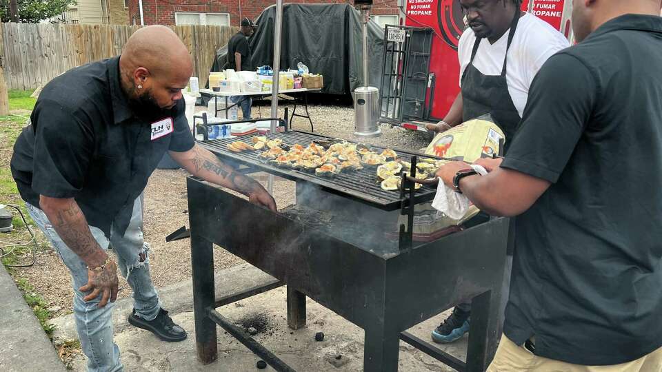 Lynn Price, left, helps Royal Bellock, middle, with a grill top during a Tiger2Dozen pop-up in Third Ward across from Turkey Leg Hut on March 2, 2024