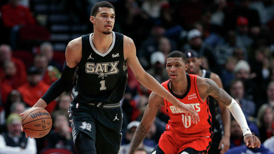 San Antonio Spurs center Victor Wembanyama (1) brings the ball down court in front of Houston Rockets forward Jabari Smith Jr. (10) during the second half of an NBA basketball game Monday, Dec. 11, 2023, in Houston. (AP Photo/Michael Wyke)