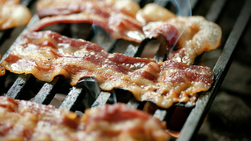 Slices of bacon being grilled,