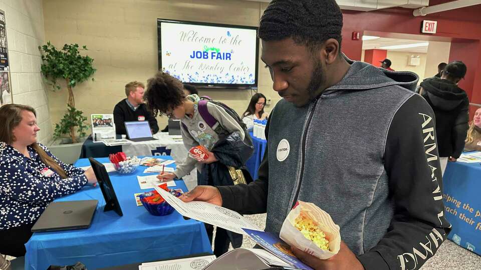 Job seeker Johannes Oveida looks over a brochure at a job fair at Lehigh Carbon Community College in Allentown, Pa., on Thursday, March 7, 2024. On Friday, March 8, 2024, the U.S. government issues its February jobs report.