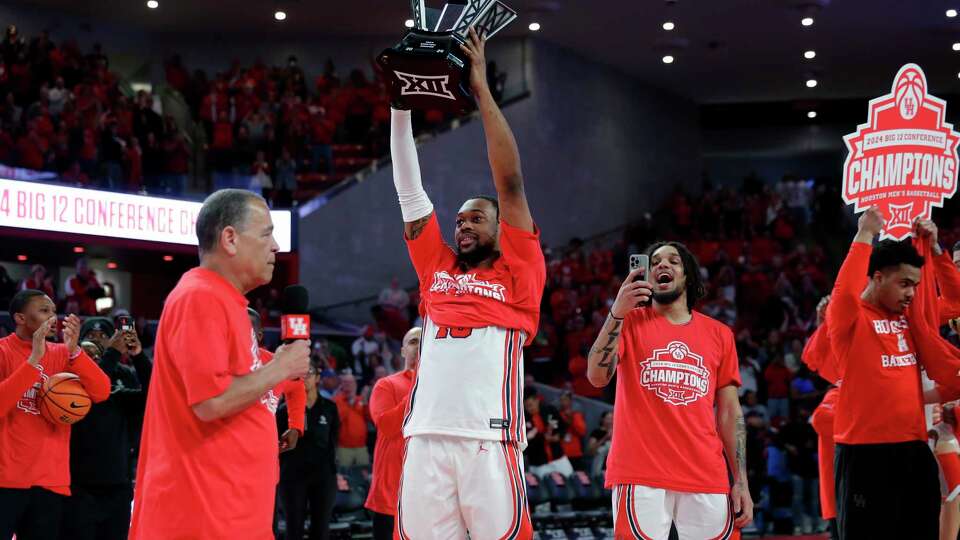 Houston head coach Kelvin Sampson, left, speaks as J'Wan Roberts, center, lifts the Big 12 trophy next to Emanuel Sharp, with phone, and Ramon Walker Jr., with sign, as they celebrate their 76-46 win over Kansas after a Big 12 baskeball game held at the Fertitta Center Saturday, Mar. 9, 2024 in Houston.