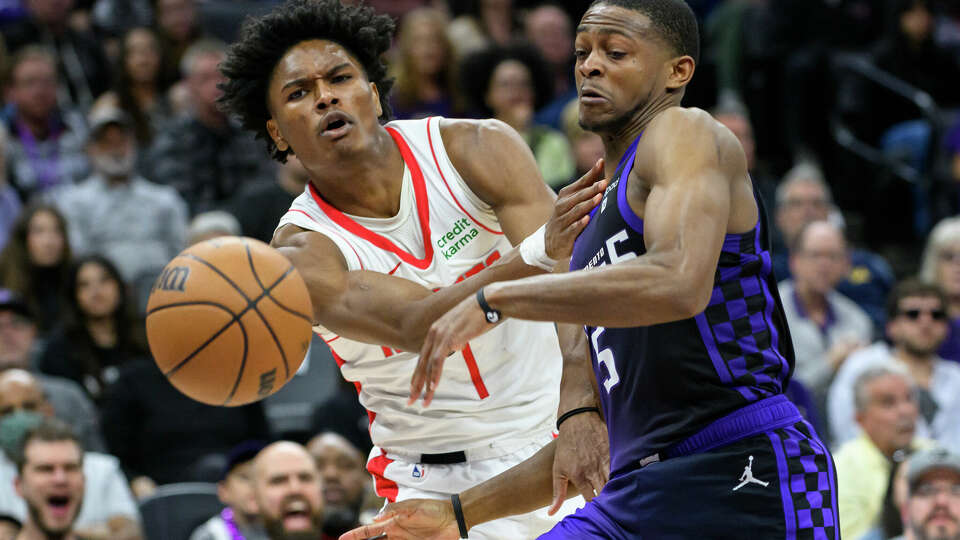 Houston Rockets forward Amen Thompson, left, and Sacramento Kings guard De'Aaron Fox scramble for the ball during the second half of an NBA basketball game in Sacramento, Calif., Sunday, March 10, 2024. The Rockets won 112-104. (AP Photo/Randall Benton)