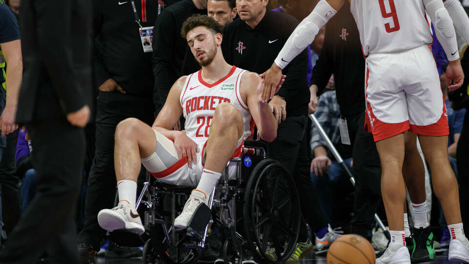 Houston Rockets center Alperen Sengun is wheeled from the arena in a wheel chair during the second half of an NBA basketball game against the Sacramento Kings in Sacramento, Calif., Sunday, March 10, 2024. (AP Photo/Randall Benton)