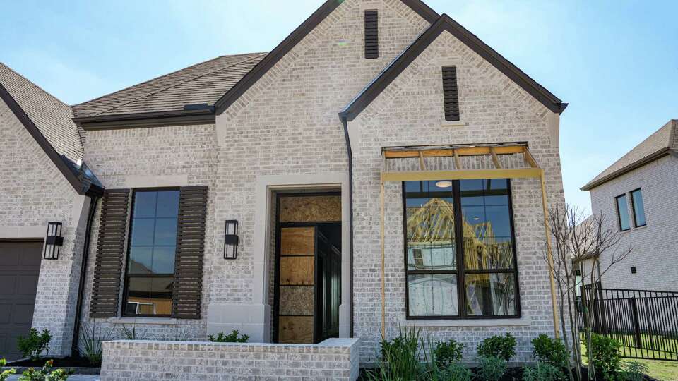 Construction is seen in the reflection of a window of a home in Prairieland Village, a Bridgeland master-planned community is photographed on Monday, March 11, 2024, in Cypress.